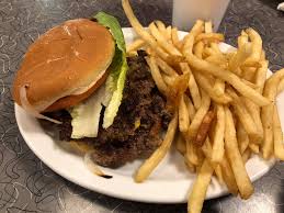 Town Topic Hamburgers signature dishes Famous Burgers (fresh-ground beef with grilled onions), Homemade Chili, Hand-Dipped Shakes, and the Truckstop Omelette.